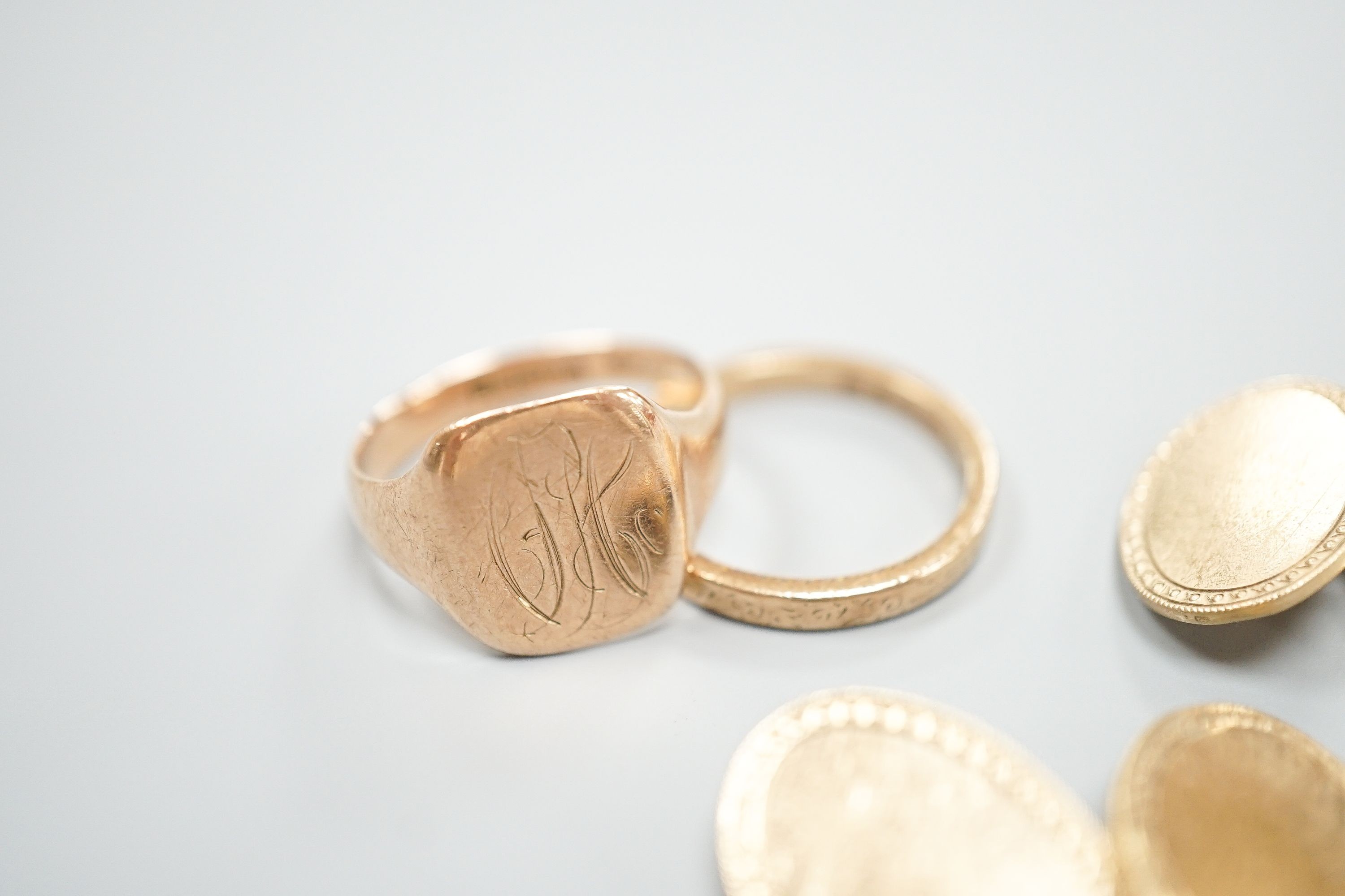 A 9ct gold wedding band, a 9ct gold signet ring and a pair of 9ct gold oval cufflinks